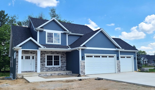 2022 W Blackberry Trl, Warsaw, IN 46582 - view of front of property with a porch, a garage, concrete driveway, stone siding, and roof with shingles