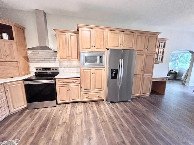 604 W Franklin St, Colfax, IN 46035 - kitchen featuring stainless steel appliances, wall chimney range hood, arched walkways, and wood finished floors