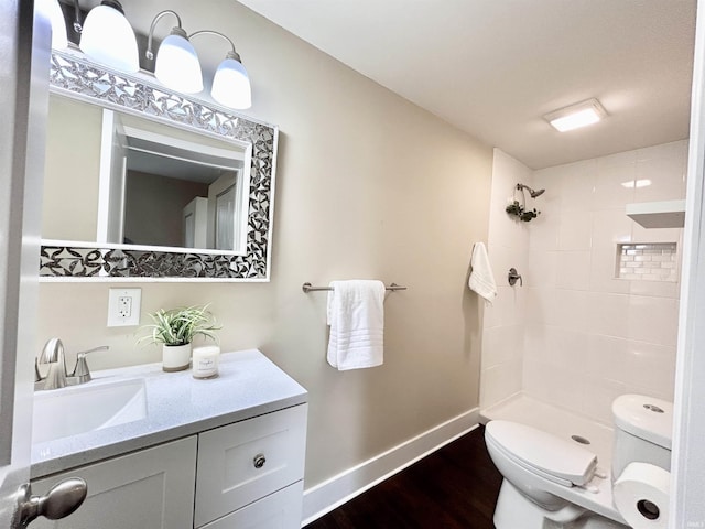 604 W Franklin St, Colfax, IN 46035 - bathroom with toilet, wood finished floors, baseboards, and tiled shower