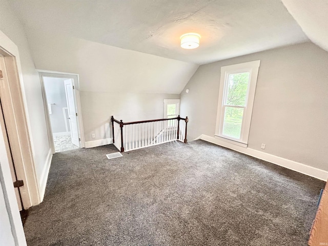 604 W Franklin St, Colfax, IN 46035 - additional living space with vaulted ceiling, dark carpet, and baseboards
