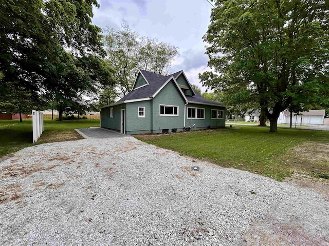 604 W Franklin St, Colfax, IN 46035 - view of front of home with gravel driveway, stucco siding, and a front yard