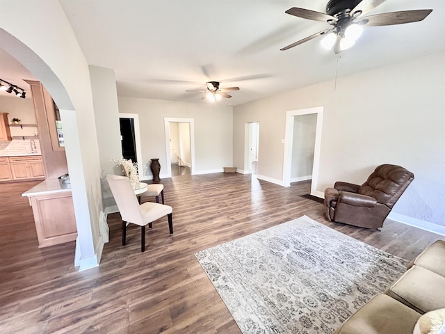 604 W Franklin St, Colfax, IN 46035 - living room featuring a ceiling fan, arched walkways, dark wood-style flooring, and baseboards