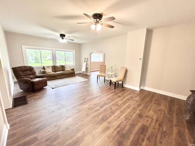 604 W Franklin St, Colfax, IN 46035 - living room featuring wood finished floors, a ceiling fan, arched walkways, and baseboards
