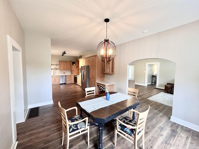 604 W Franklin St, Colfax, IN 46035 - dining space with arched walkways, a chandelier, baseboards, and dark wood finished floors