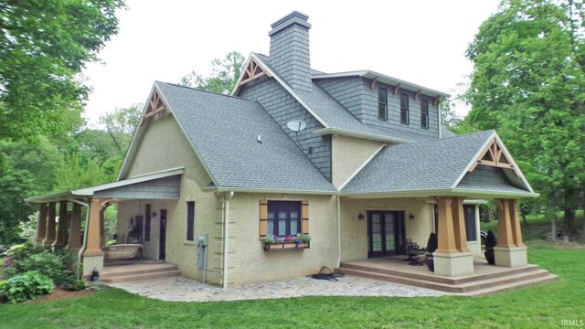 113 Lakewood Dr, Vincennes, IN 47591 - back of property featuring covered porch, roof with shingles, a chimney, french doors, and a yard