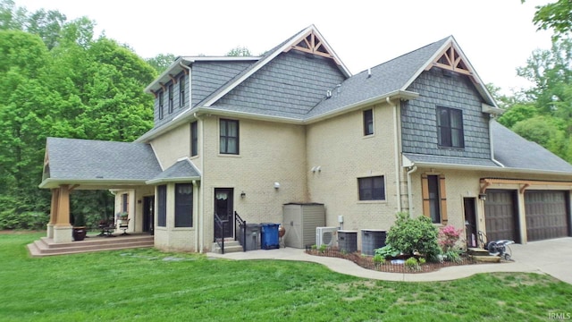 113 Lakewood Dr, Vincennes, IN 47591 - rear view of house featuring a yard, brick siding, concrete driveway, an attached garage, and central air condition unit