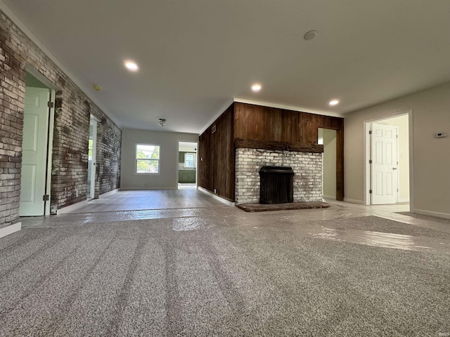 6701 E Hickory Ln, Muncie, IN 47303 - unfurnished living room featuring a fireplace, light colored carpet, brick wall, baseboards, and recessed lighting