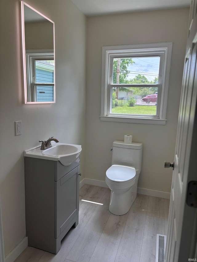 6701 E Hickory Ln, Muncie, IN 47303 - bathroom with toilet, vanity, wood finished floors, and baseboards
