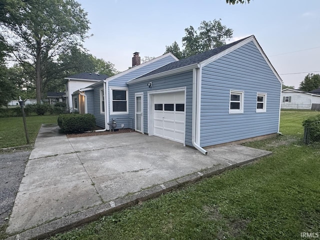 6701 E Hickory Ln, Muncie, IN 47303 - view of property exterior with a lawn, a chimney, concrete driveway, and a garage