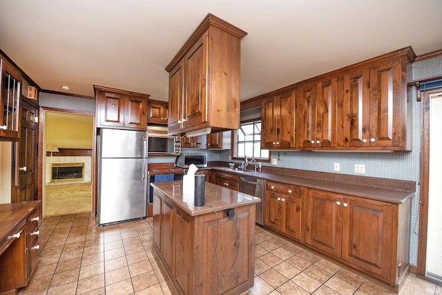 1301 E 4th St, Fowler, IN 47944 - kitchen with appliances with stainless steel finishes, a center island, light tile patterned floors, and a fireplace