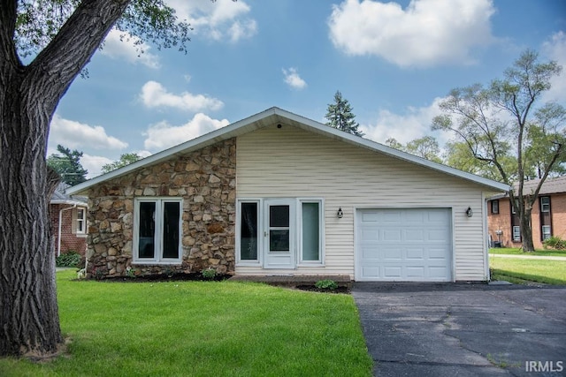 1105 W Tilmor Dr, Muncie, IN 47303 - view of front facade featuring stone siding, a front yard, driveway, and a garage