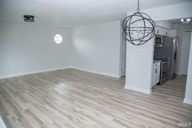 1105 W Tilmor Dr, Muncie, IN 47303 - unfurnished living room with a chandelier, light wood-style flooring, a textured ceiling, and baseboards