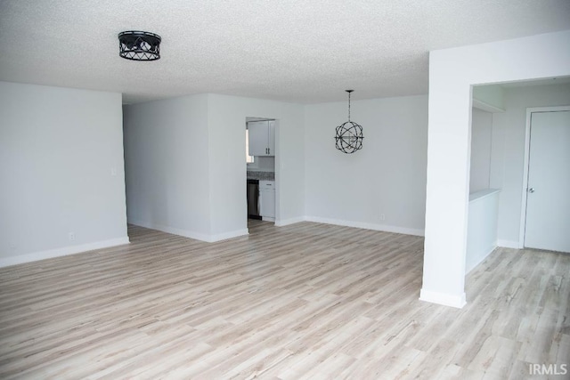 1105 W Tilmor Dr, Muncie, IN 47303 - unfurnished living room featuring light wood-type flooring, a textured ceiling, and baseboards