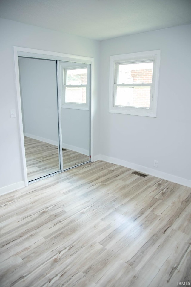 1105 W Tilmor Dr, Muncie, IN 47303 - unfurnished bedroom with wood finished floors, a closet, and baseboards