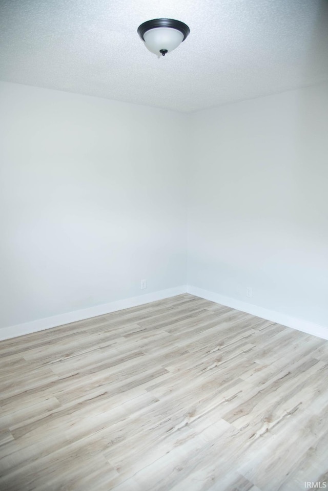 1105 W Tilmor Dr, Muncie, IN 47303 - spare room featuring wood finished floors, baseboards, and a textured ceiling