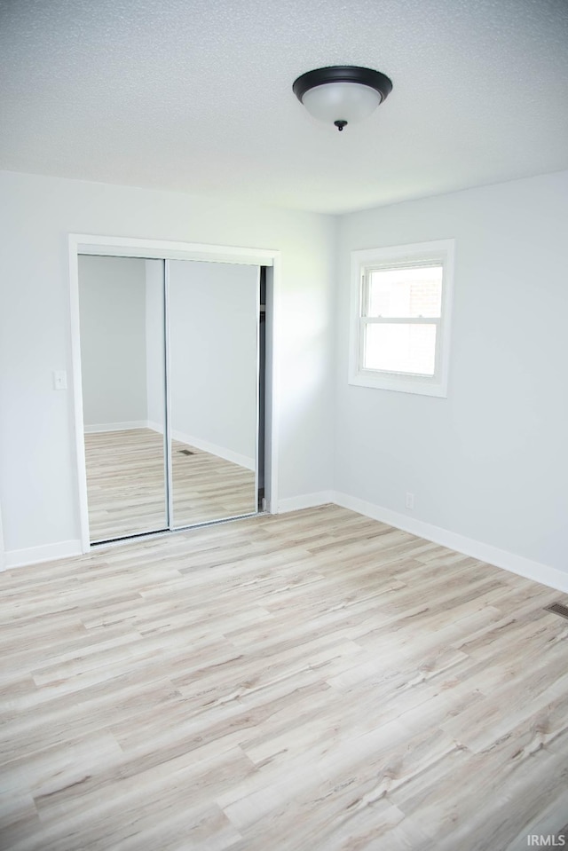 1105 W Tilmor Dr, Muncie, IN 47303 - unfurnished bedroom with a closet, wood finished floors, and baseboards