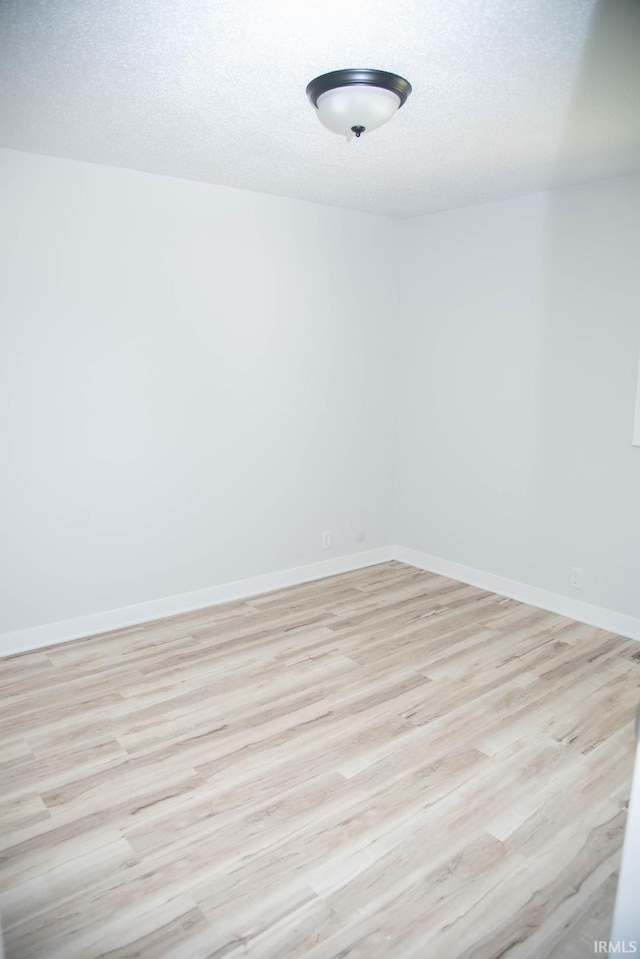 1105 W Tilmor Dr, Muncie, IN 47303 - unfurnished room featuring light wood finished floors, baseboards, and a textured ceiling