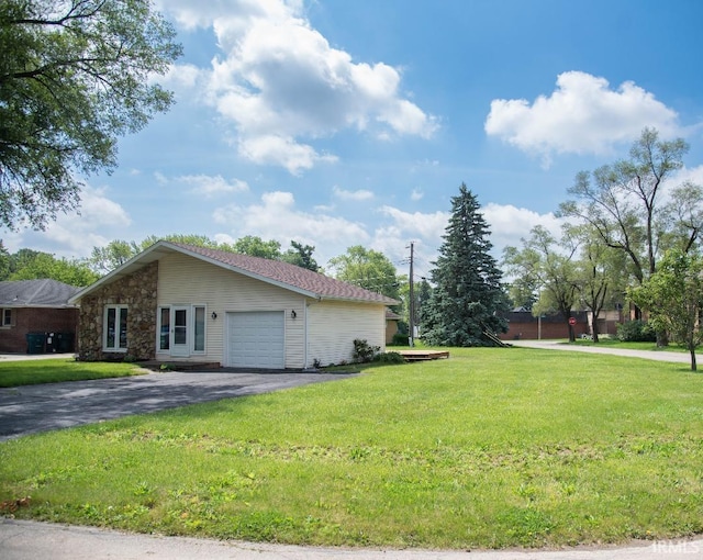 1105 W Tilmor Dr, Muncie, IN 47303 - view of side of home with a garage, asphalt driveway, a yard, and stone siding