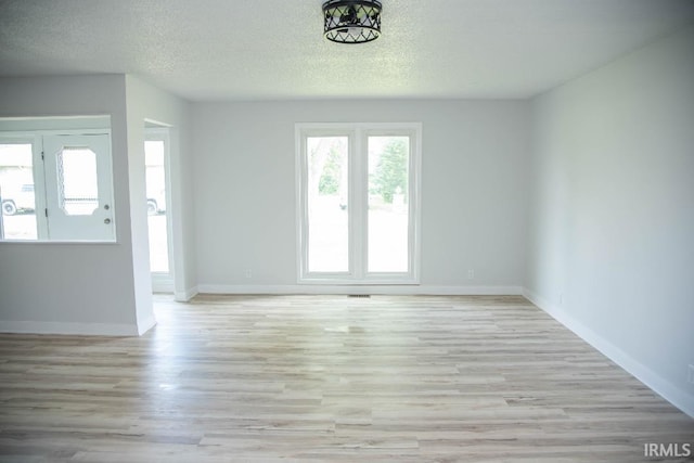 1105 W Tilmor Dr, Muncie, IN 47303 - unfurnished living room with wood finished floors, a textured ceiling, and baseboards