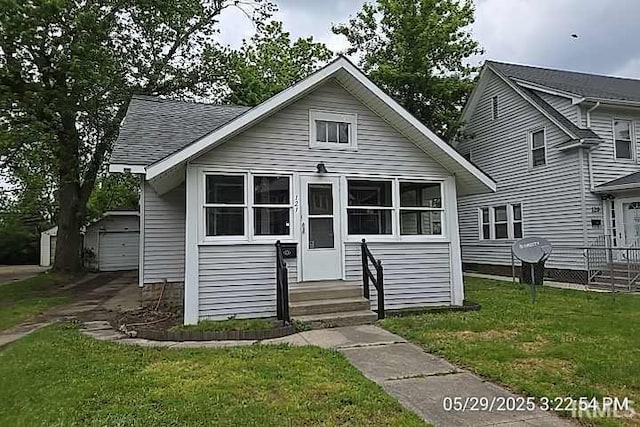 121 Altgeld St, South Bend, IN 46614 - bungalow-style home featuring an outbuilding, a front lawn, entry steps, a garage, and a shingled roof