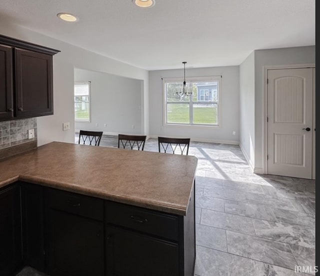 3981 Gussie Ct, Warsaw, IN 46582 - kitchen with a peninsula, plenty of natural light, backsplash, open floor plan, and recessed lighting