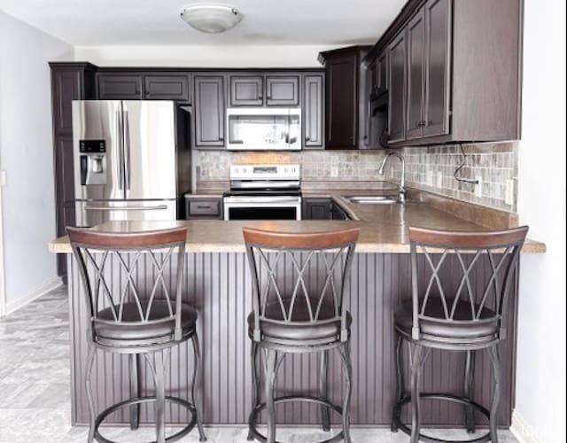3981 Gussie Ct, Warsaw, IN 46582 - kitchen with appliances with stainless steel finishes, a sink, decorative backsplash, and baseboards