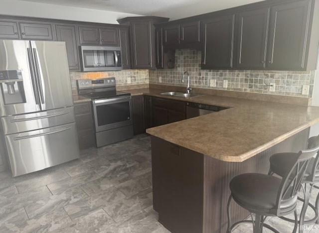 3981 Gussie Ct, Warsaw, IN 46582 - kitchen featuring appliances with stainless steel finishes, a sink, a peninsula, and tasteful backsplash