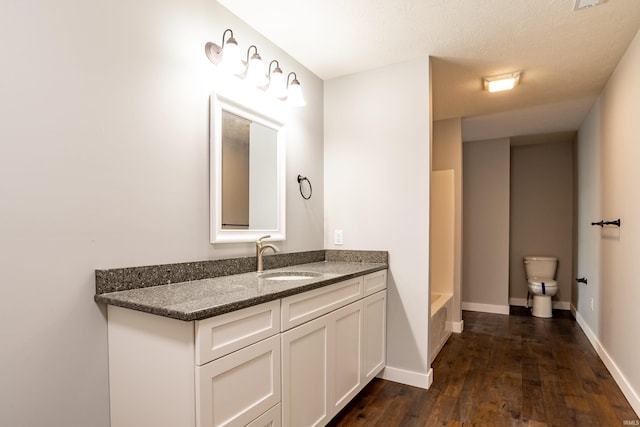 2075 N Russell Rd, Bloomington, IN 47408 - bathroom with vanity, toilet, wood finished floors, and baseboards