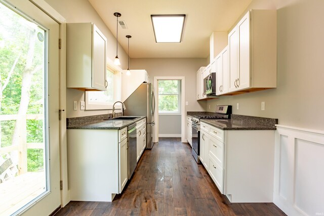 2075 N Russell Rd, Bloomington, IN 47408 - kitchen featuring appliances with stainless steel finishes, a sink, dark wood finished floors, white cabinetry, and pendant lighting