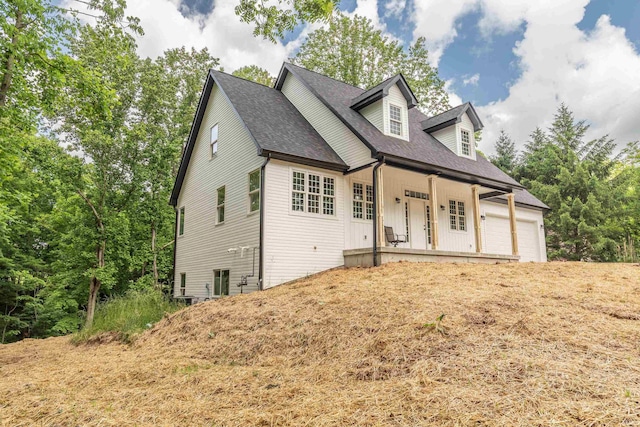 2075 N Russell Rd, Bloomington, IN 47408 - cape cod home featuring a porch, a garage, and a shingled roof