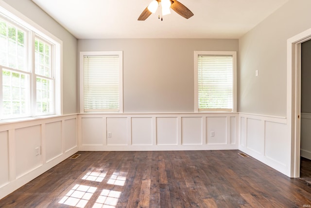 2075 N Russell Rd, Bloomington, IN 47408 - unfurnished room featuring ceiling fan, a decorative wall, dark wood finished floors, and wainscoting