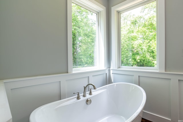 2075 N Russell Rd, Bloomington, IN 47408 - bathroom with a decorative wall, a freestanding tub, and wainscoting