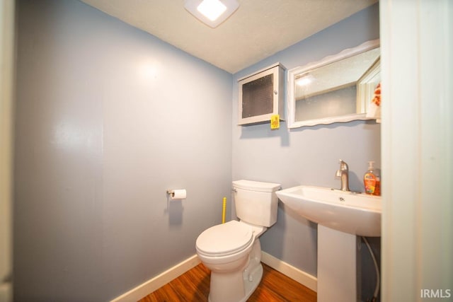819 Spring St, New Castle, IN 47362 - bathroom with wood finished floors, toilet, and baseboards