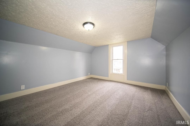 819 Spring St, New Castle, IN 47362 - additional living space featuring a textured ceiling, baseboards, lofted ceiling, and carpet flooring