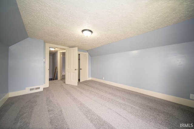 819 Spring St, New Castle, IN 47362 - additional living space featuring a textured ceiling, baseboards, vaulted ceiling, and carpet