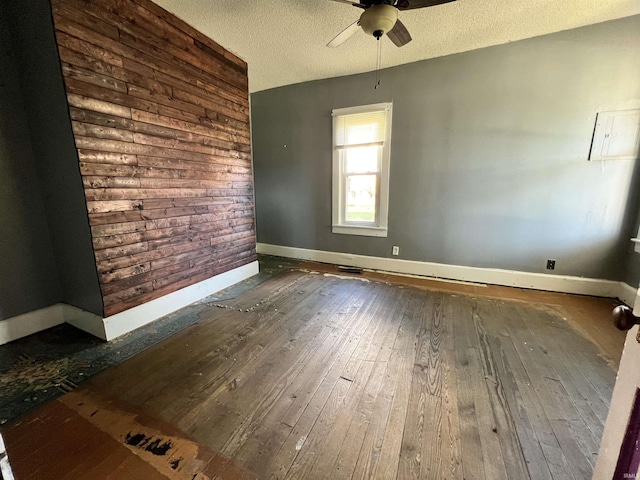 216 W Walnut St, Boonville, IN 47601 - empty room with hardwood / wood-style flooring, a ceiling fan, baseboards, a textured ceiling, and wooden walls