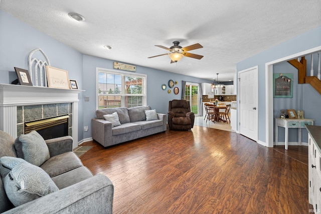 2034 Windflower Pl, West Lafayette, IN 47906 - living room featuring ceiling fan, dark wood-style floors, a tile fireplace, baseboards, and a textured ceiling