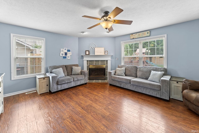 2034 Windflower Pl, West Lafayette, IN 47906 - living area with dark wood-style floors, a tile fireplace, a ceiling fan, baseboards, and a textured ceiling