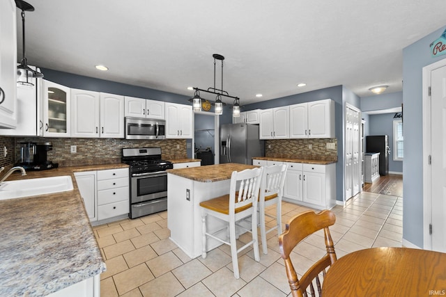 2034 Windflower Pl, West Lafayette, IN 47906 - kitchen featuring appliances with stainless steel finishes, a sink, light tile patterned floors, backsplash, and recessed lighting