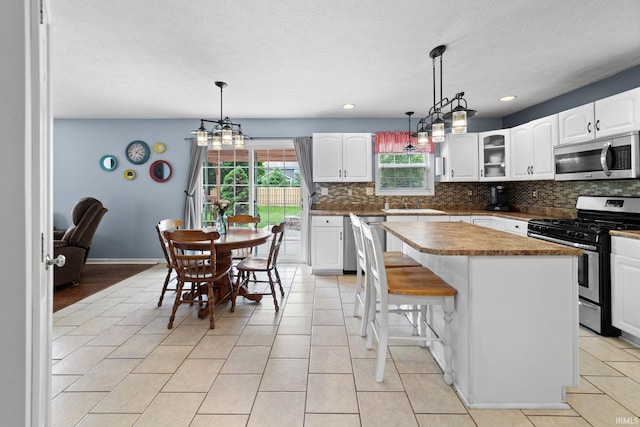 2034 Windflower Pl, West Lafayette, IN 47906 - kitchen featuring appliances with stainless steel finishes, backsplash, a kitchen island, white cabinetry, and pendant lighting