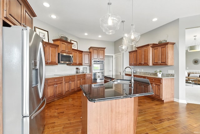 101 Twin Eagles Blvd W, Huntertown, IN 46748 - kitchen with appliances with stainless steel finishes, a sink, light wood-style floors, a center island with sink, and brown cabinets