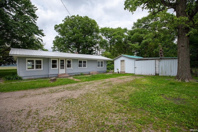 8147 15th Rd, Argos, IN 46501 - rear view of property featuring metal roof, an outbuilding, a lawn, driveway, and entry steps