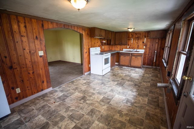 8147 15th Rd, Argos, IN 46501 - kitchen with white electric range, wood walls, arched walkways, brown cabinets, and stone finish floors