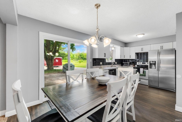 4618 Kekionga Dr, Fort Wayne, IN 46809 - dining space with a chandelier, dark wood-style flooring, a textured ceiling, and baseboards