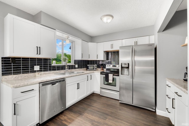 4618 Kekionga Dr, Fort Wayne, IN 46809 - kitchen with appliances with stainless steel finishes, a sink, decorative backsplash, dark wood finished floors, and a textured ceiling