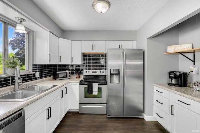 4618 Kekionga Dr, Fort Wayne, IN 46809 - kitchen featuring appliances with stainless steel finishes, a sink, white cabinets, backsplash, and a textured ceiling