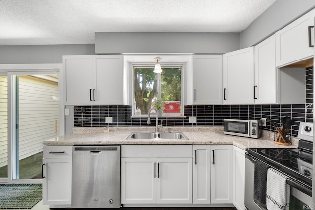 4618 Kekionga Dr, Fort Wayne, IN 46809 - kitchen featuring appliances with stainless steel finishes, a sink, white cabinets, tasteful backsplash, and light countertops