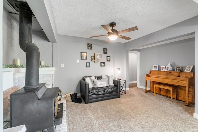 4618 Kekionga Dr, Fort Wayne, IN 46809 - carpeted living area with a wood stove, ceiling fan, a textured ceiling, and baseboards