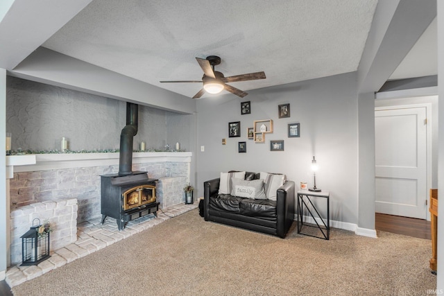 4618 Kekionga Dr, Fort Wayne, IN 46809 - carpeted living room with a ceiling fan, a textured ceiling, a wood stove, and baseboards