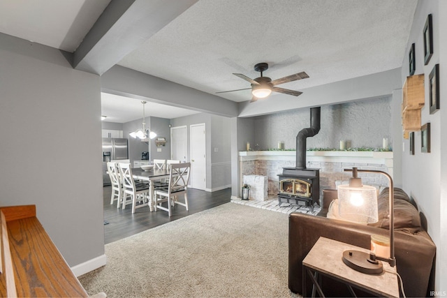 4618 Kekionga Dr, Fort Wayne, IN 46809 - living area featuring carpet floors, a ceiling fan, a wood stove, baseboards, and a textured ceiling